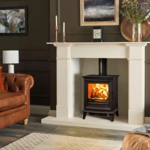 Black wood burning stove inside a cream fireplace surround in a traditional living room