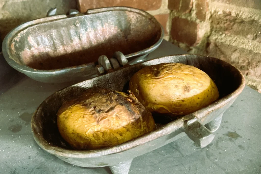 Cast iron potato baker for cooking potatoes inside a fireplace or stove
